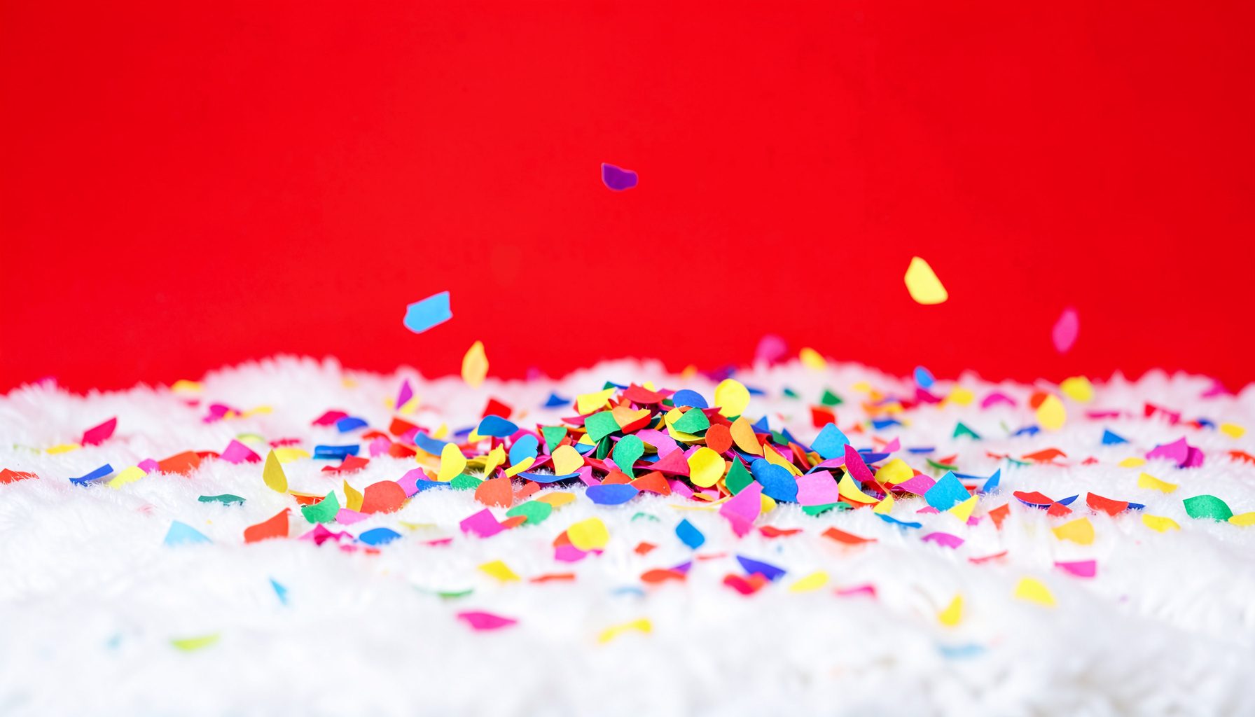 Colorful paper confetti scattered on a soft white surface, conveying celebration and activity